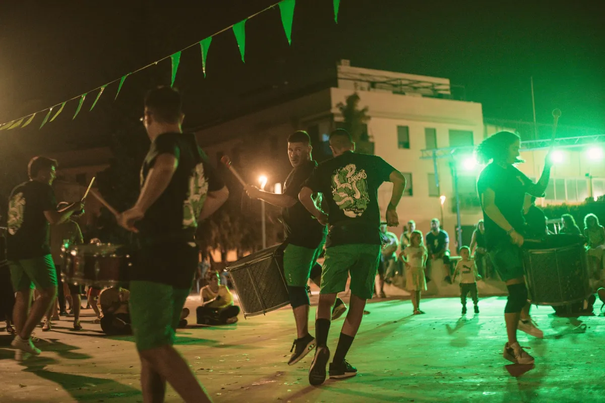 Drakaris tocant de nit a la Drakafesta, sota llums verds
